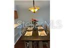 A dining room features a dark wood table with place settings under a pendant light — 5433 LAKE MARGARET DRIVE UNIT E 195, ORLANDO, FL