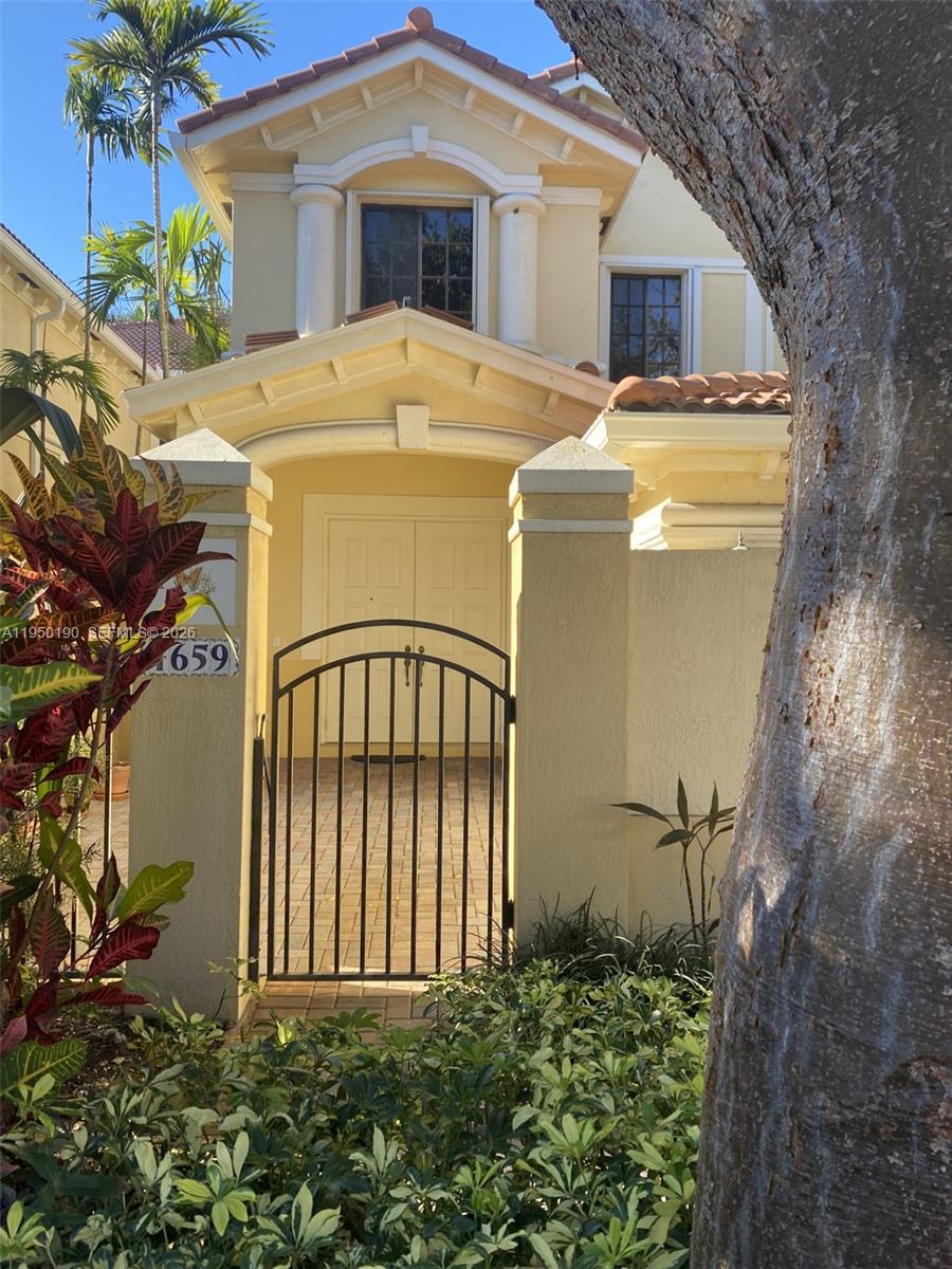 A two-story stucco house with a tile roof, a garage, and a gated entrance — 1659 Passion Vine Cir # 4, Weston FL 33326, WESTON, FL