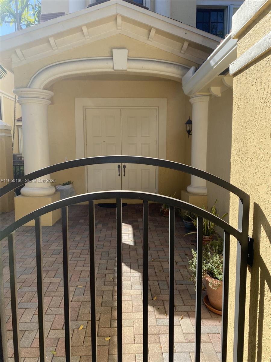 A concrete driveway with rust-colored staining leads toward a residential building surrounded by trees — 1659 Passion Vine Cir # 4, Weston FL 33326, WESTON, FL