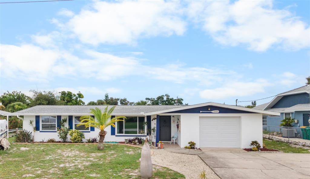 A single-story house with a white exterior, blue trim, a garage, and a front yard — 2113 GEORGIA AVENUE, ENGLEWOOD, FL