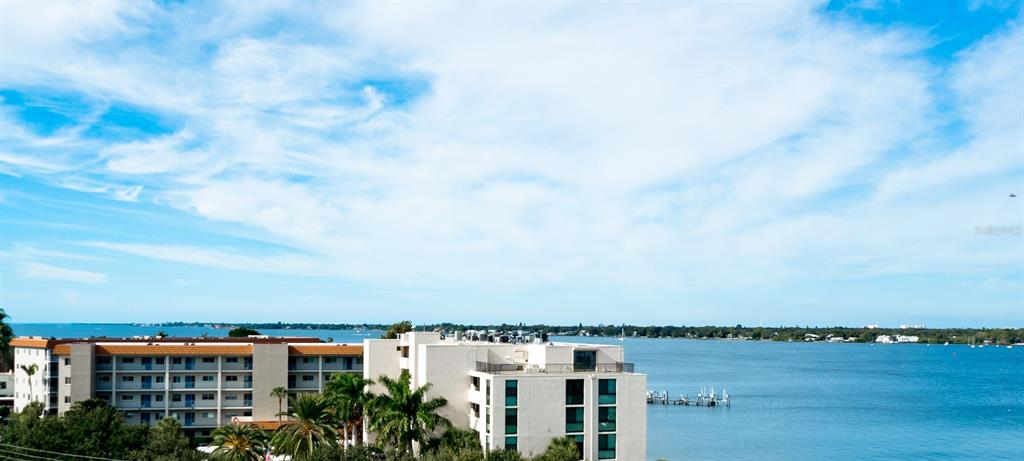 An exterior view of a multi-story apartment building overlooking a large body of water — 1400 1ST AVENUE W UNIT 806, BRADENTON, FL