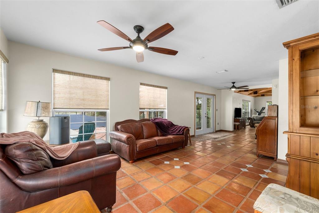 A living room features terracotta tile flooring, a leather sofa, and a ceiling fan — 340 SE 30TH AVENUE, TRENTON, FL