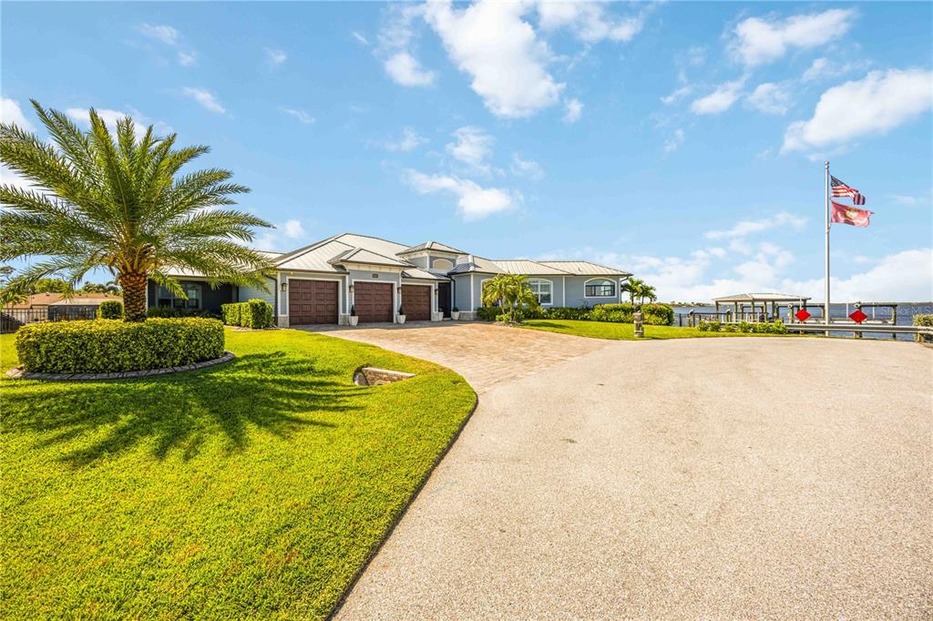 A single-story house with a three-car garage and a dock sits along the water — 4179 SPIRE STREET, PORT CHARLOTTE, FL