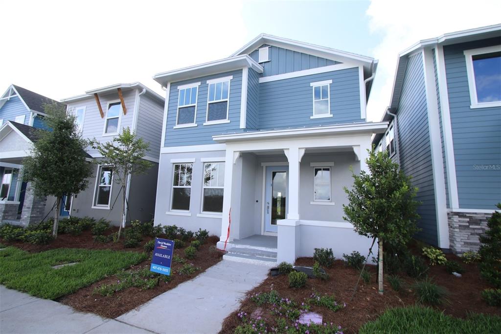 A two-story blue and gray house with a front porch and a small yard — 9434 HARTLINE WAY, ORLANDO, FL