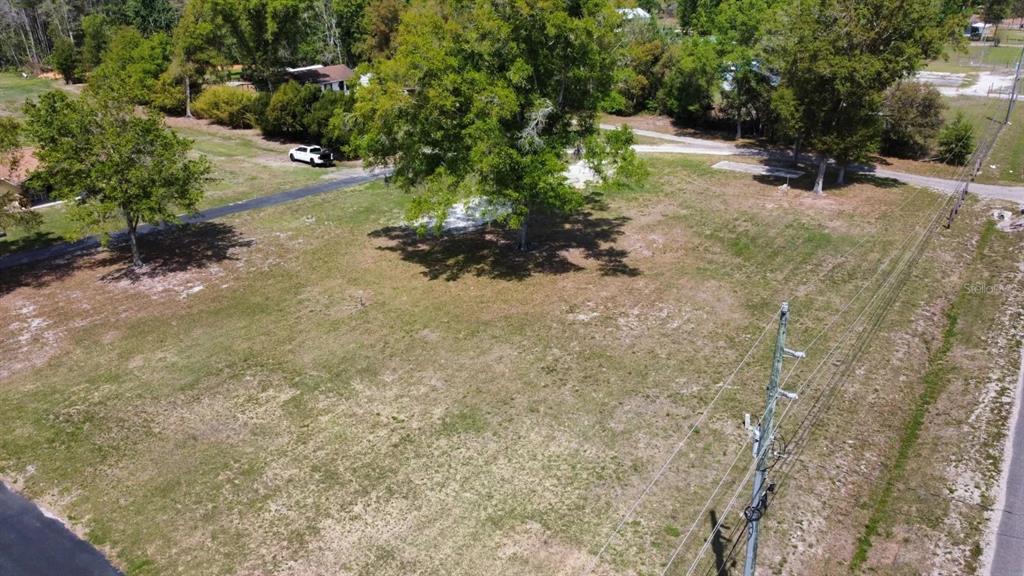An aerial view shows a grassy, vacant lot with several trees and a utility pole — STATE ROAD 33, CLERMONT, FL