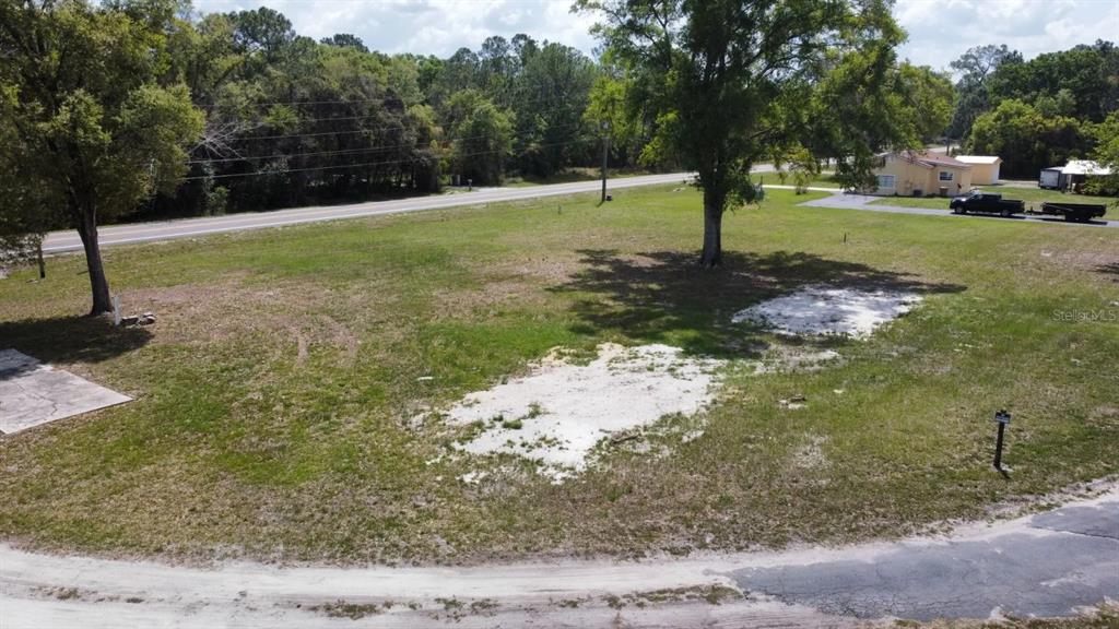 An elevated view of a vacant, grassy residential lot with scattered trees and sandy patches — STATE ROAD 33, CLERMONT, FL