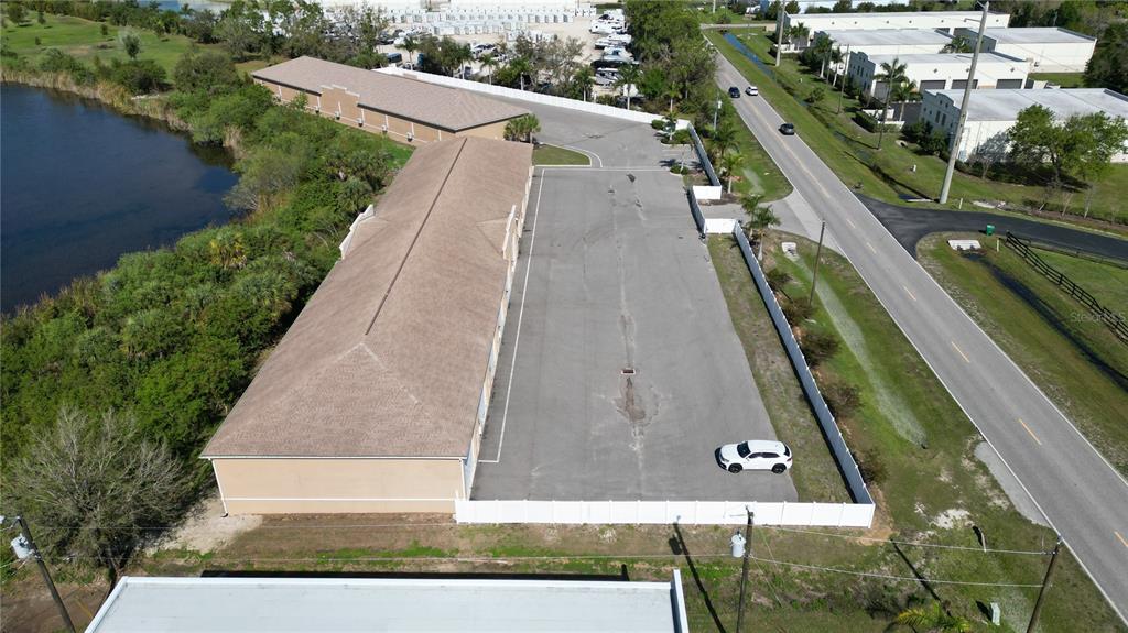 An aerial view shows a commercial building with an adjacent parking lot beside a road — 3921 TAYLOR ROAD UNIT A1, PUNTA GORDA, FL