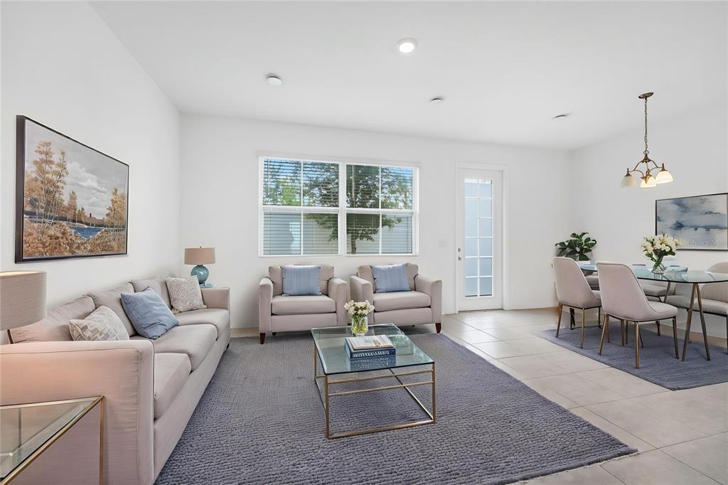 A living and dining area features light-colored furniture, a glass coffee table, and tile flooring — 763 LONGBOAT DRIVE, DAVENPORT, FL