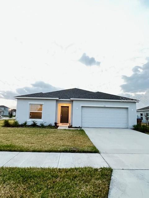 A single-story suburban house with a two-car garage and a front-facing window — 200 AQUAMARINE LANE, KISSIMMEE, FL