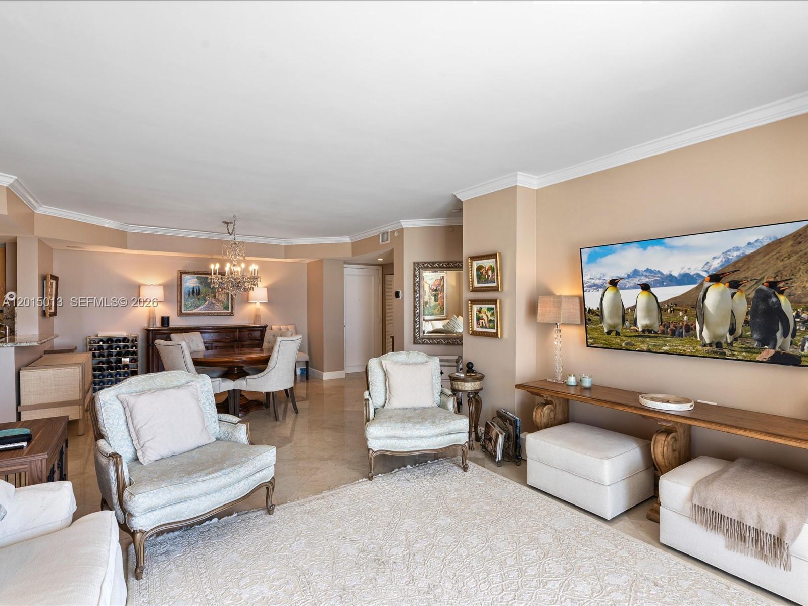A living and dining area features light-colored furniture, a large television, and tile flooring — 701 Brickell Key Blvd # 2511, Miami FL 33131, MIAMI, FL