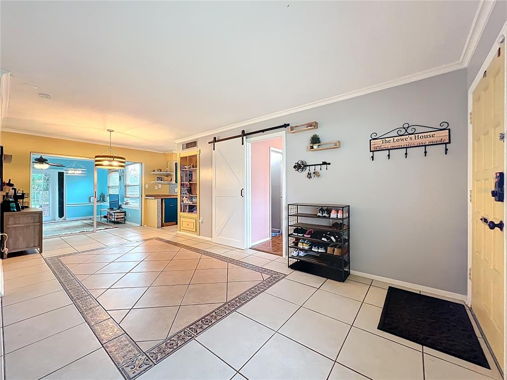 A tiled entryway features a shoe rack, a sliding barn door, and a wall-mounted coat rack — 1098 HENRY BALCH DRIVE, ORLANDO, FL