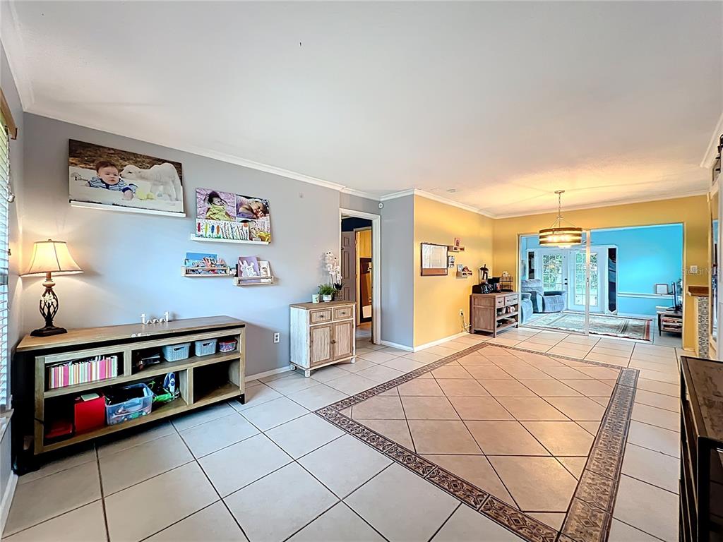 A living room with light gray and yellow walls, tile flooring, and a wooden console — 1098 HENRY BALCH DRIVE, ORLANDO, FL