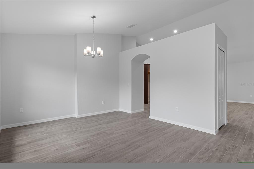 A room with light gray walls, wood-look tile flooring, and a modern chandelier — 4118 N PINK POPPY DRIVE, BEVERLY HILLS, FL