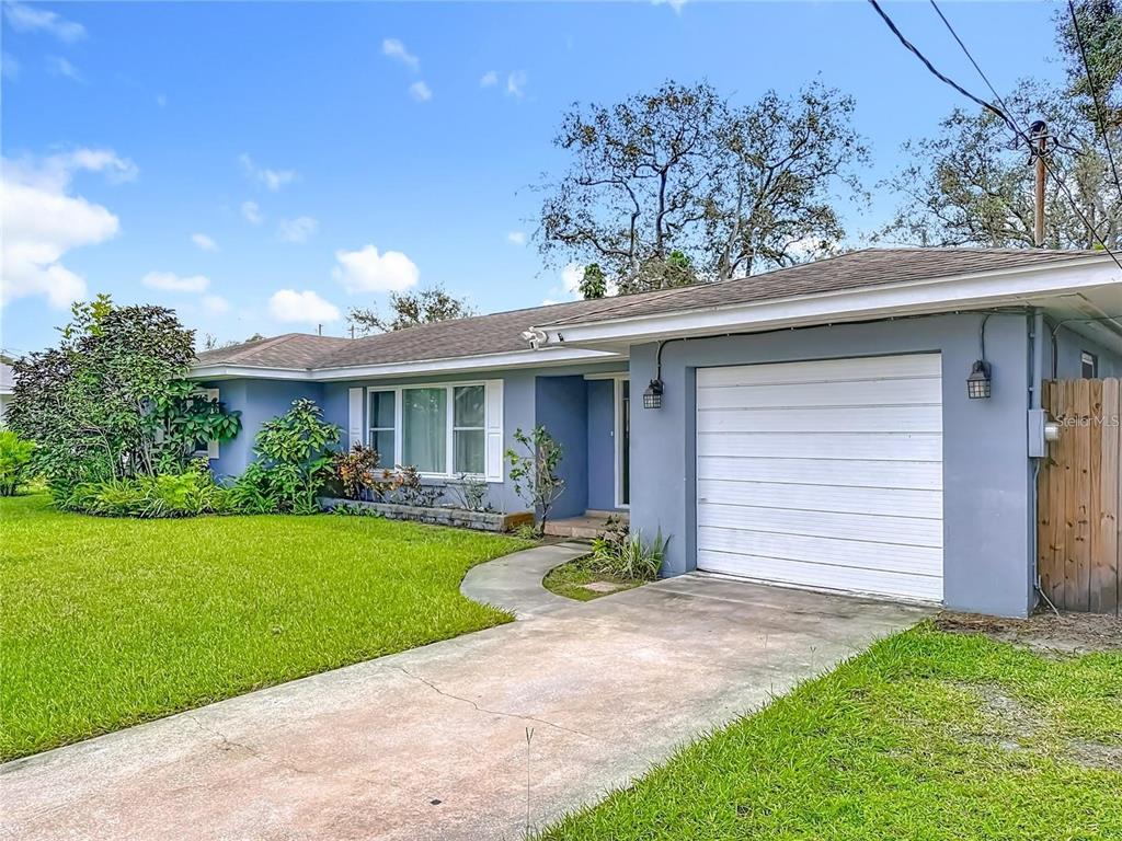 A single-story house with a blue exterior, a white garage door, and a front lawn — 14626 WILDWOOD DRIVE, LARGO, FL