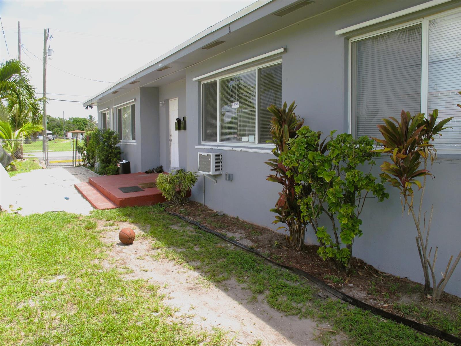 A gray single-story house exterior with a red concrete porch, window air conditioner, and landscaping — 340 NW 6th Street # 2, Pompano Beach FL 33060, POMPANO BEACH, FL