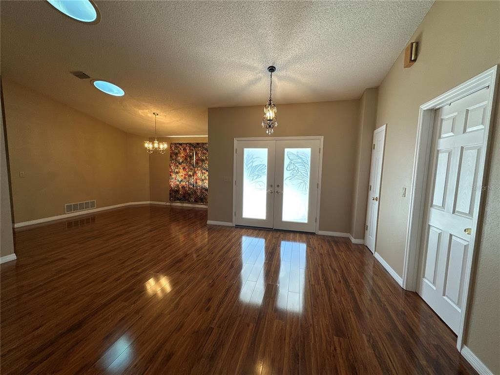An entryway with wood flooring, a chandelier, and double front doors with glass panels — 100 WEBSTER LANE, PALM COAST, FL