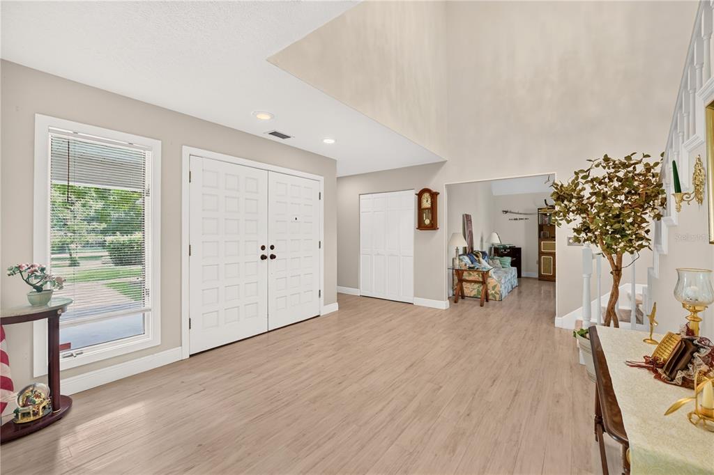 A spacious foyer features light wood-look flooring, a double front door, and a high ceiling — 5360 NE 1ST LANE, OCALA, FL