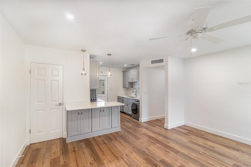 A kitchen with gray cabinets, a white countertop, and wood-look flooring in an open room — 151 N ORLANDO AVENUE UNIT 207, WINTER PARK, FL