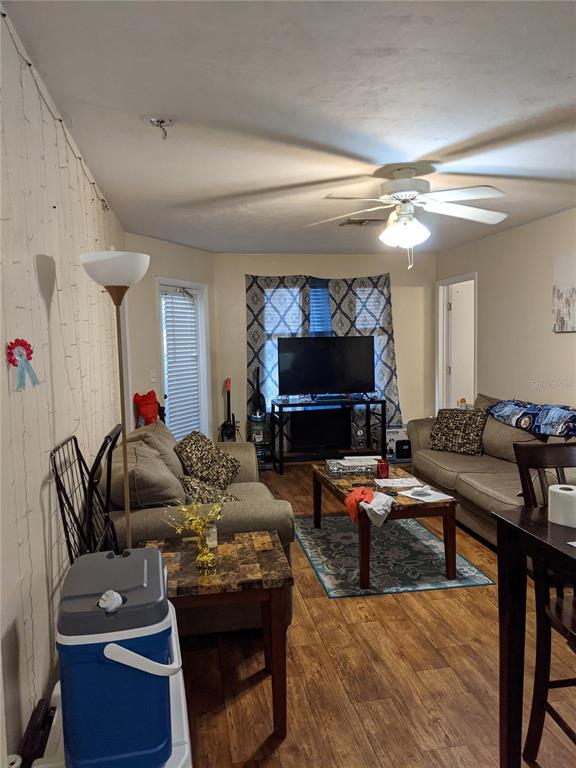 A living room features wood-look flooring, a ceiling fan, a television, and a sofa — 4000 SW 23RD STREET UNIT 5-106, GAINESVILLE, FL
