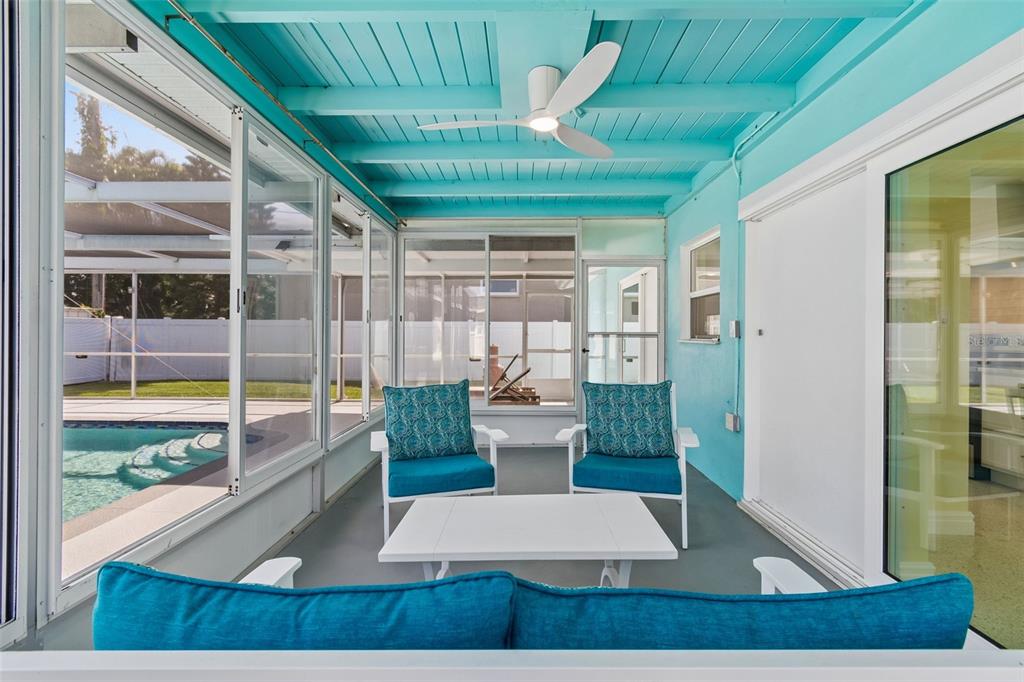 A sunroom with a bright blue ceiling, two chairs, a coffee table, and pool views — 4388 50TH PLACE S, ST PETERSBURG, FL