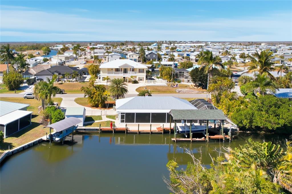 An aerial view of a waterfront house with a boat dock and a screened lanai — 2740 SANIBEL BOULEVARD, ST JAMES CITY, FL