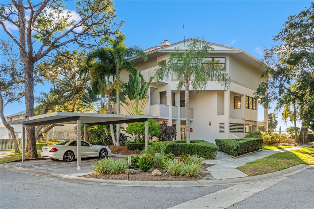 A three-story apartment building with a covered parking space and a white car — 300 S FLORIDA AVENUE UNIT 600F, TARPON SPRINGS, FL
