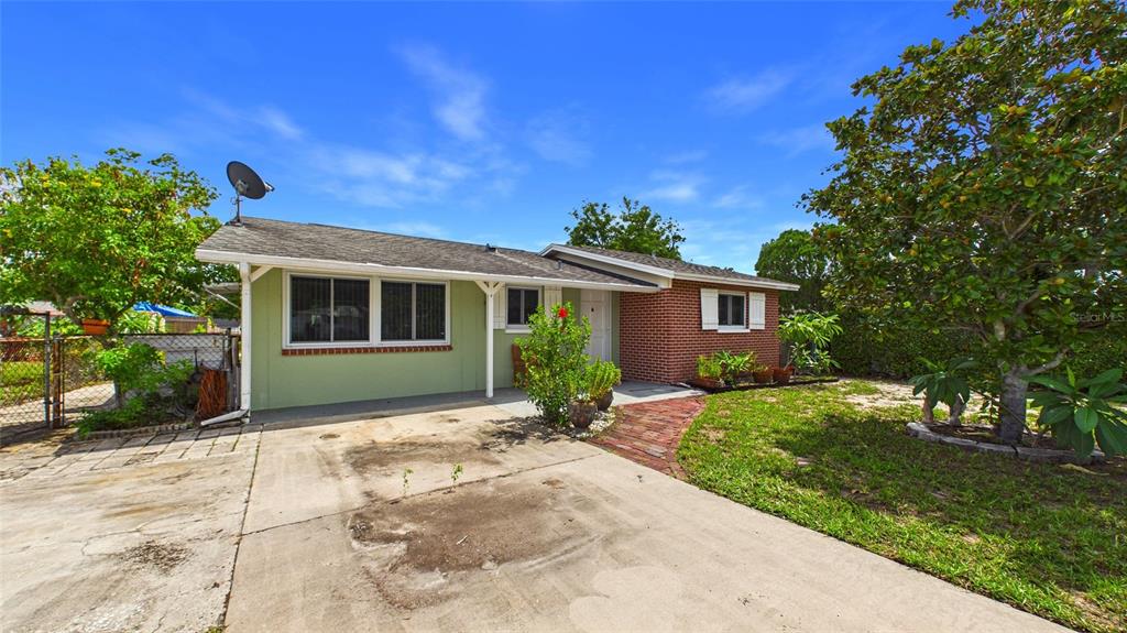 A single-story house features a green exterior, a brick facade, and a concrete driveway — 2809 EDENWOOD STREET, CLEARWATER, FL