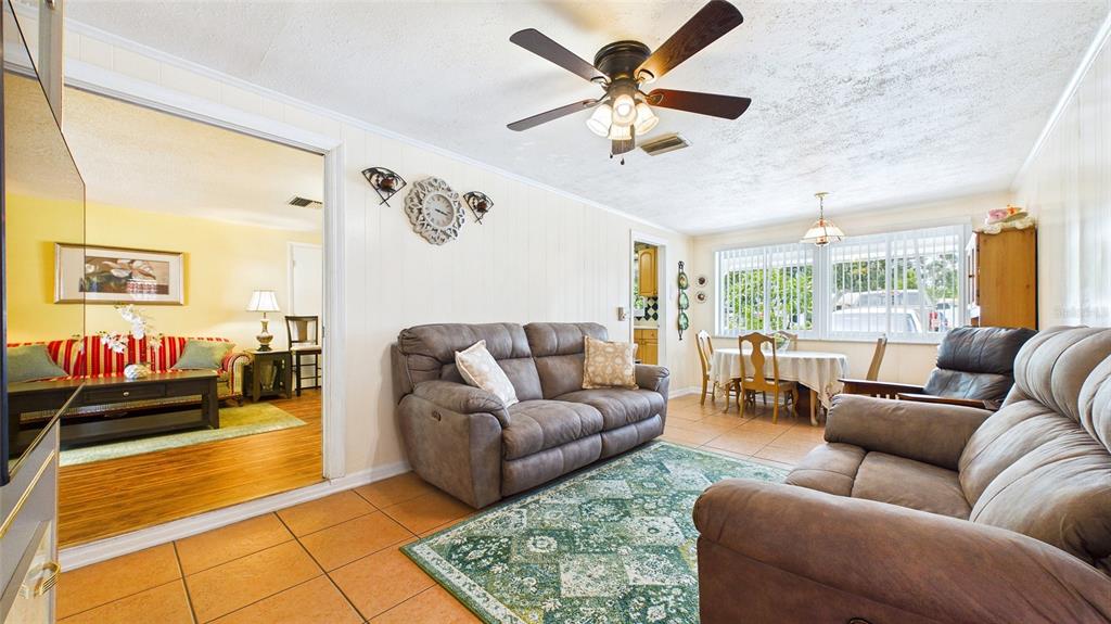 A living room with tile floors, a ceiling fan, and a view into another room — 2809 EDENWOOD STREET, CLEARWATER, FL