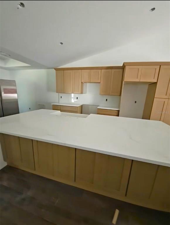 A kitchen features light wood cabinets, a large white island, and stainless steel appliances — 7 FIR DRIVE TRACK, OCALA, FL