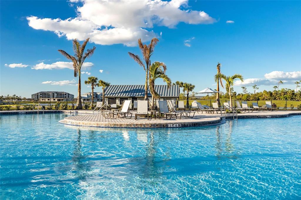 A swimming pool with lounge chairs on a paved deck surrounded by palm trees — 14061 HERITAGE LANDING BOULEVARD UNIT 411, PUNTA GORDA, FL