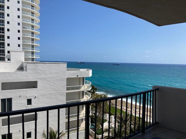 A balcony view overlooking the ocean, a sandy beach, and a neighboring high-rise building — 4200 N Ocean Drive # 905, Riviera Beach FL 33404, RIVIERA BEACH, FL