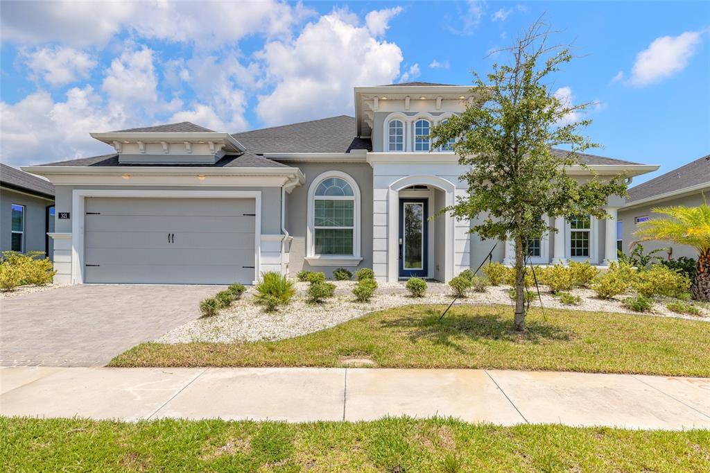 A single-story house features a gray garage, white trim, and a blue front door — 321 AQUAMARINE WAY, DAYTONA BEACH, FL