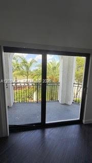 A view through a sliding glass door shows a balcony with a metal railing — 15500 SW 136th St. # 211, Miami FL 33196, MIAMI, FL