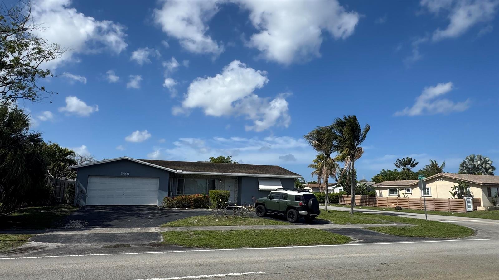 A single-story gray house with a white garage door and a green SUV parked outside — 5401 W Park Road, Hollywood FL 33021, HOLLYWOOD, FL
