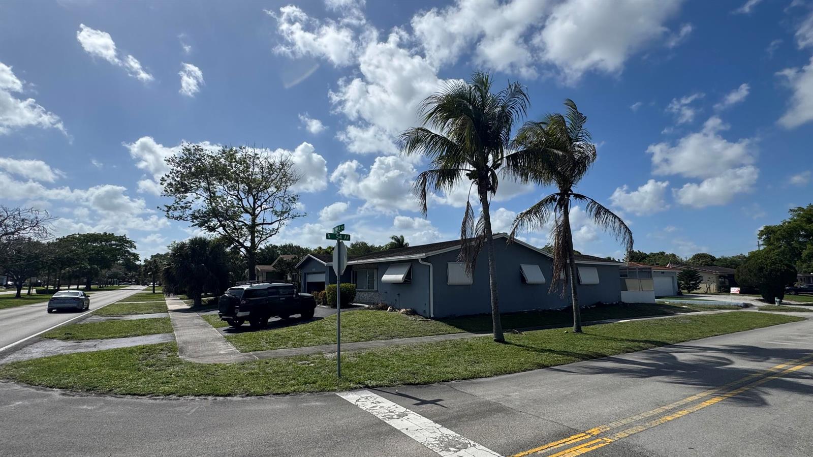 A gray single-story house with palm trees and a parked vehicle on a corner lot — 5401 W Park Road, Hollywood FL 33021, HOLLYWOOD, FL