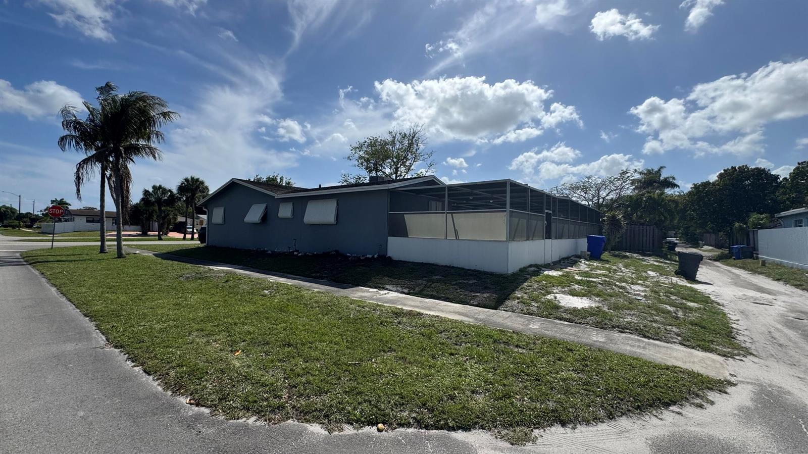 A gray single-story house features a screened-in patio and a corner lot location — 5401 W Park Road, Hollywood FL 33021, HOLLYWOOD, FL