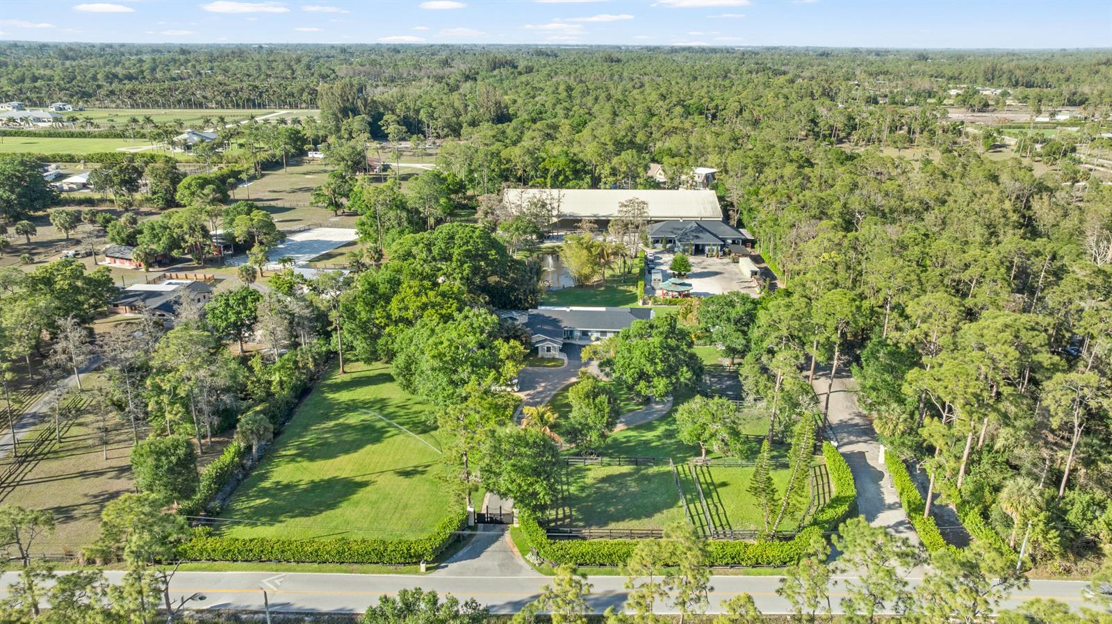 An aerial view shows a large residential property with a house, barn, and wooded grounds — 15161 Collecting Canal Road, FL 33470, FL