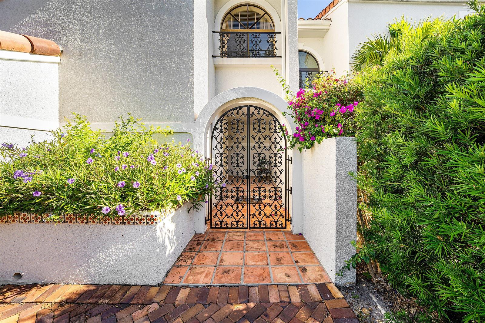 An arched wrought iron gate leads to a tiled entryway with a white stucco facade — 5560 N Ocean Boulevard # A, Ocean Ridge FL 33435, OCEAN RIDGE, FL