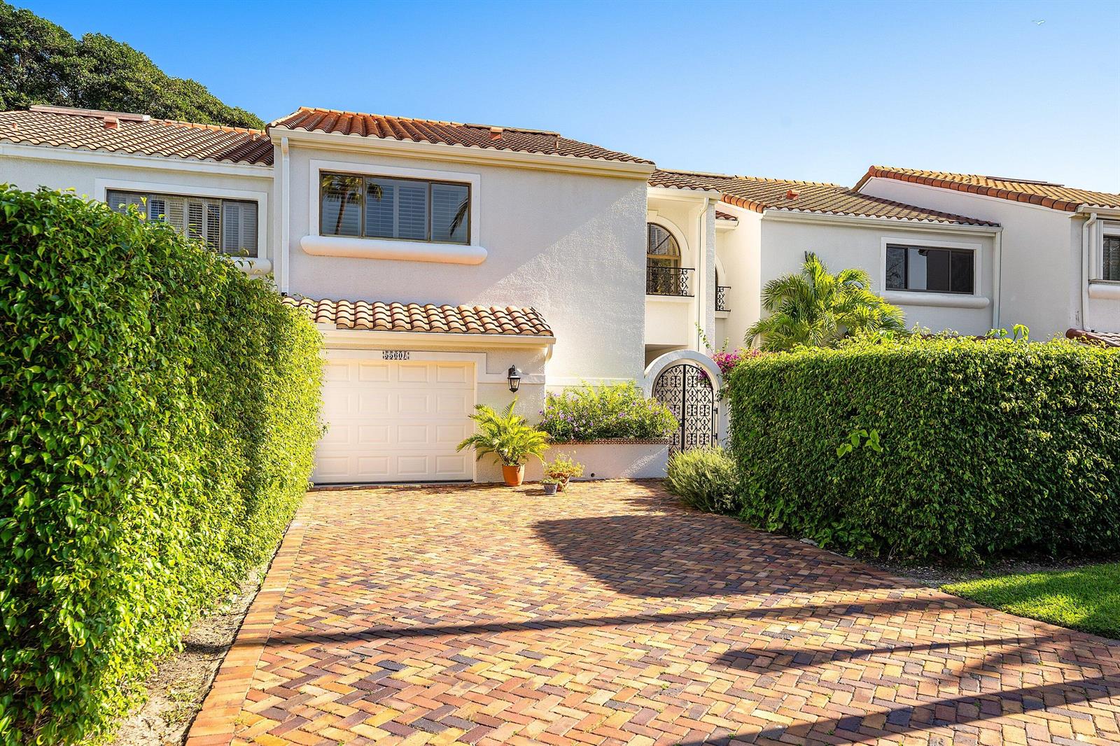 A two-story white stucco townhouse with a brick driveway and a gated courtyard entrance — 5560 N Ocean Boulevard # A, Ocean Ridge FL 33435, OCEAN RIDGE, FL