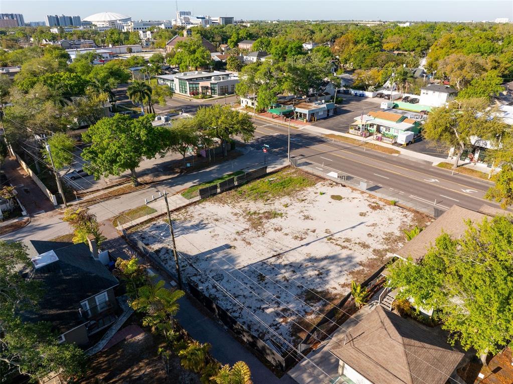 An aerial view shows a vacant, fenced-in rectangular lot situated between two houses and a road — 1201 DR MARTIN LUTHER KING JR STREET N, ST PETERSBURG, FL