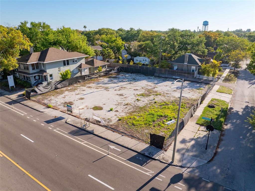 An aerial view shows a vacant, fenced-in corner lot situated between two residential houses — 1201 DR MARTIN LUTHER KING JR STREET N, ST PETERSBURG, FL