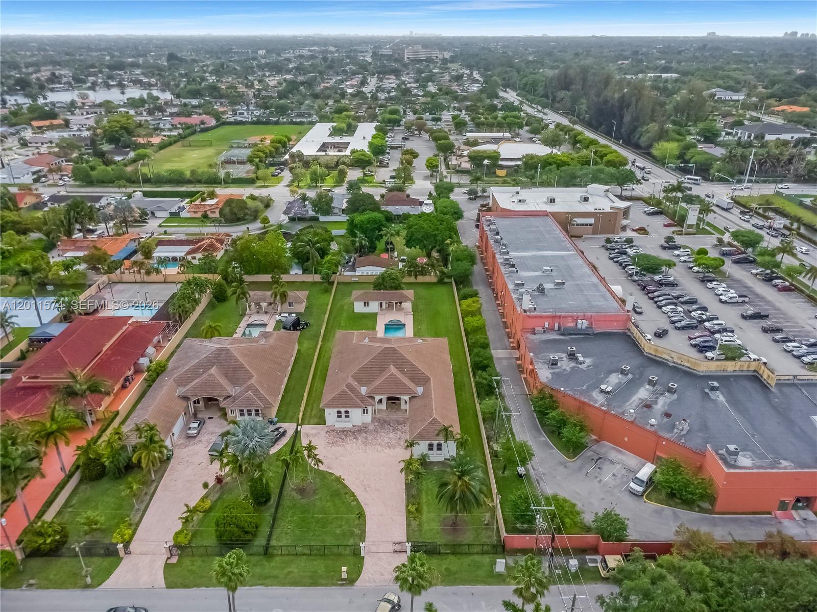 An aerial view shows two residential houses with pools next to a large commercial building — 4025 SW 128th Ave, Miami FL 33175, MIAMI, FL