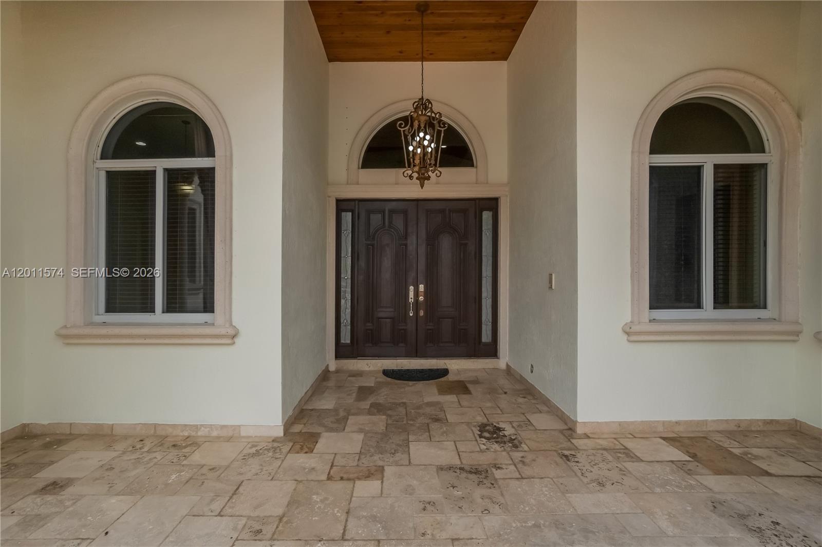 A covered entryway features a double door, arched windows, and a stone-tiled floor — 4025 SW 128th Ave, Miami FL 33175, MIAMI, FL