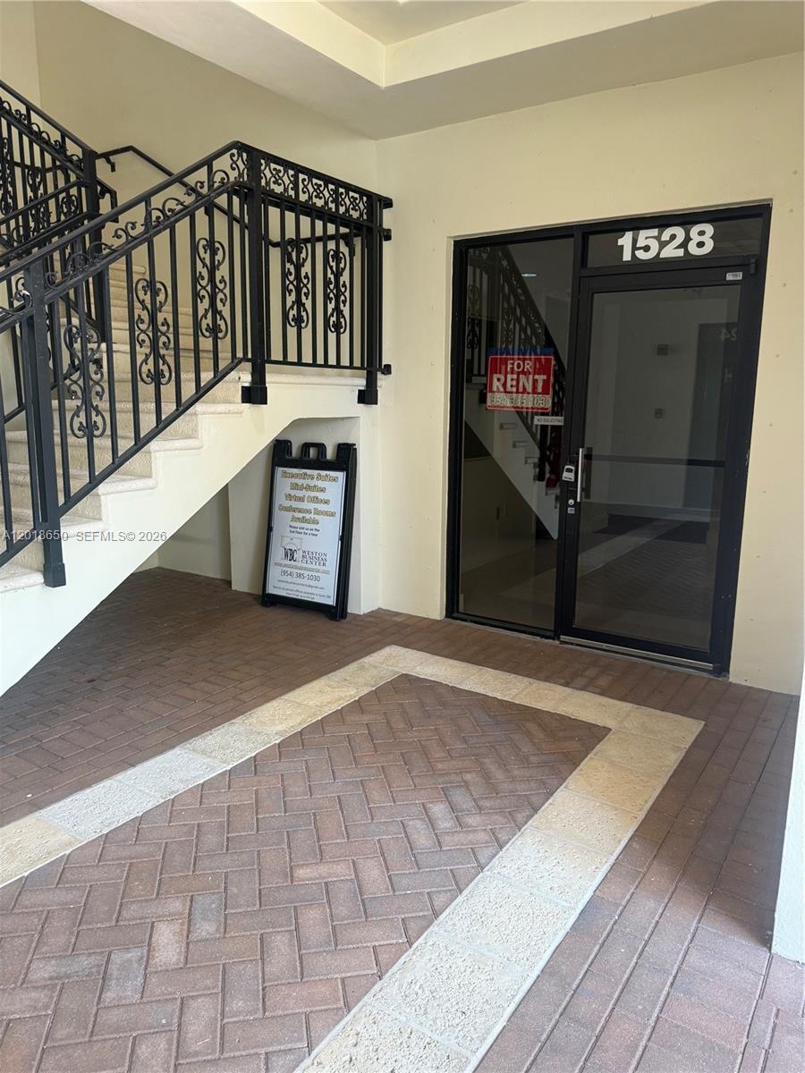 An exterior view shows a glass door labeled 1528 next to a staircase with iron railings — 1528 Weston Rd, Weston FL 33326, WESTON, FL