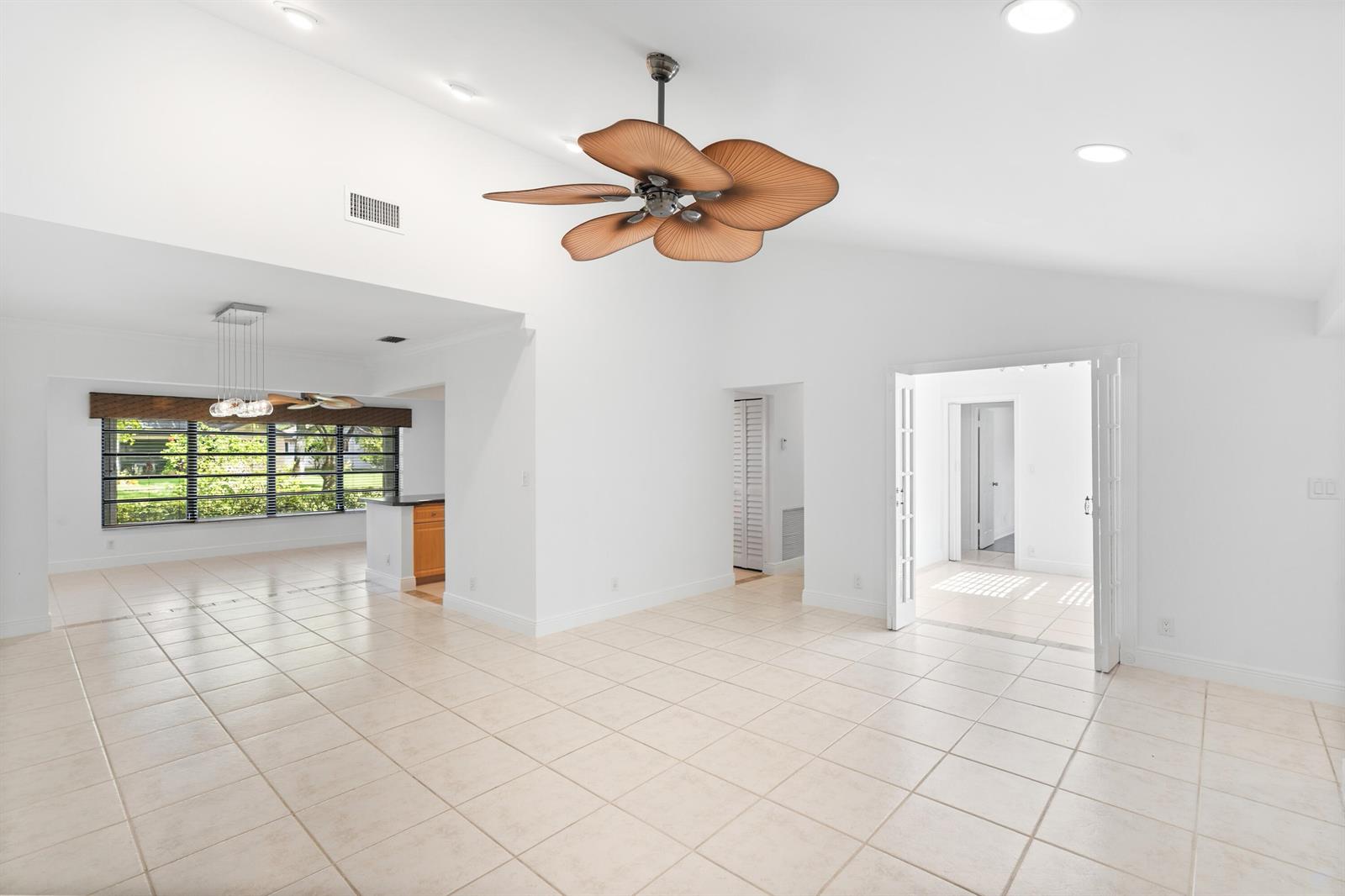 A bright, open living room features white walls, tiled floors, and a palm-leaf ceiling fan — 18051 S 104th Ter Terrace S, Boca Raton FL 33498, BOCA RATON, FL
