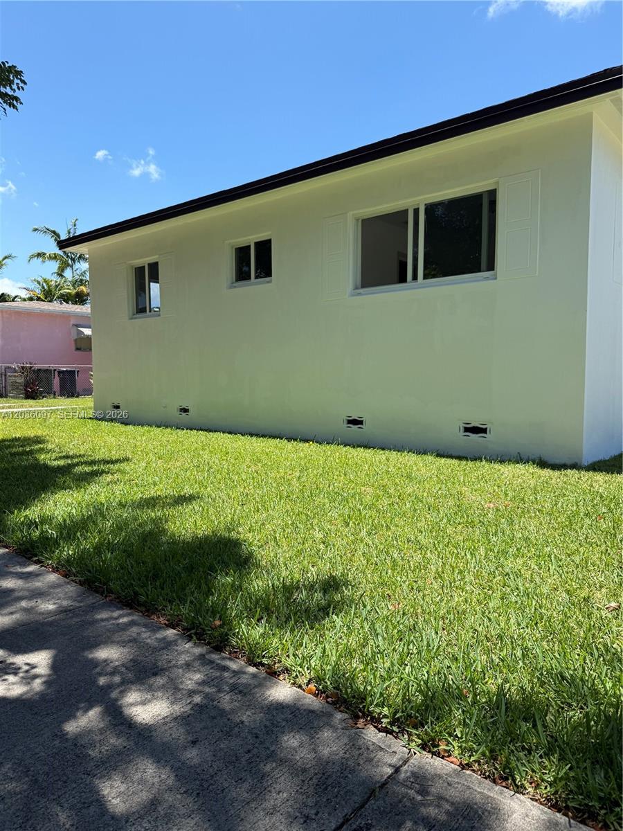 The exterior side of a white house features a lawn and several windows — 1460 SW 65th Ave, West Miami FL 33144, WEST MIAMI, FL