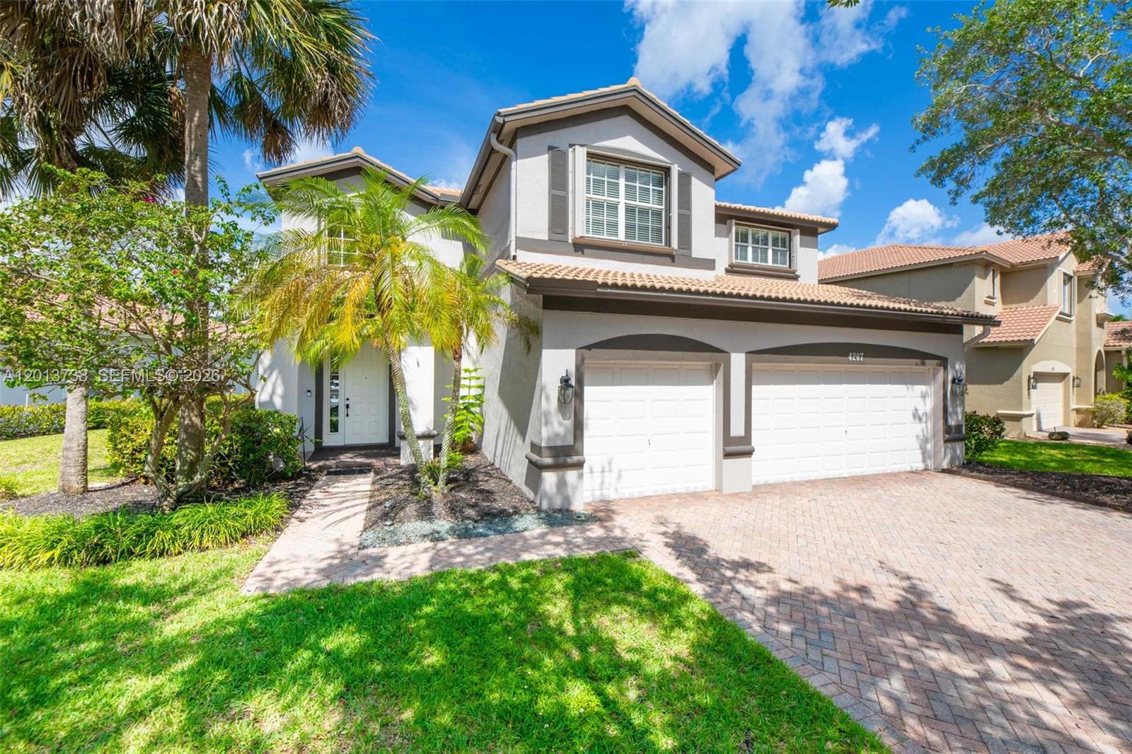 A two-story house with a two-car garage, a paved driveway, and a palm tree — 4207 W Whitewater Ave, Weston FL 33332, WESTON, FL