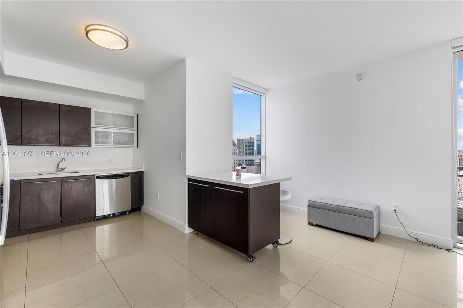 A modern kitchen features dark wood cabinets, stainless steel appliances, and a portable kitchen island — 90 SW 3rd St # 2504, Miami FL 33130, MIAMI, FL