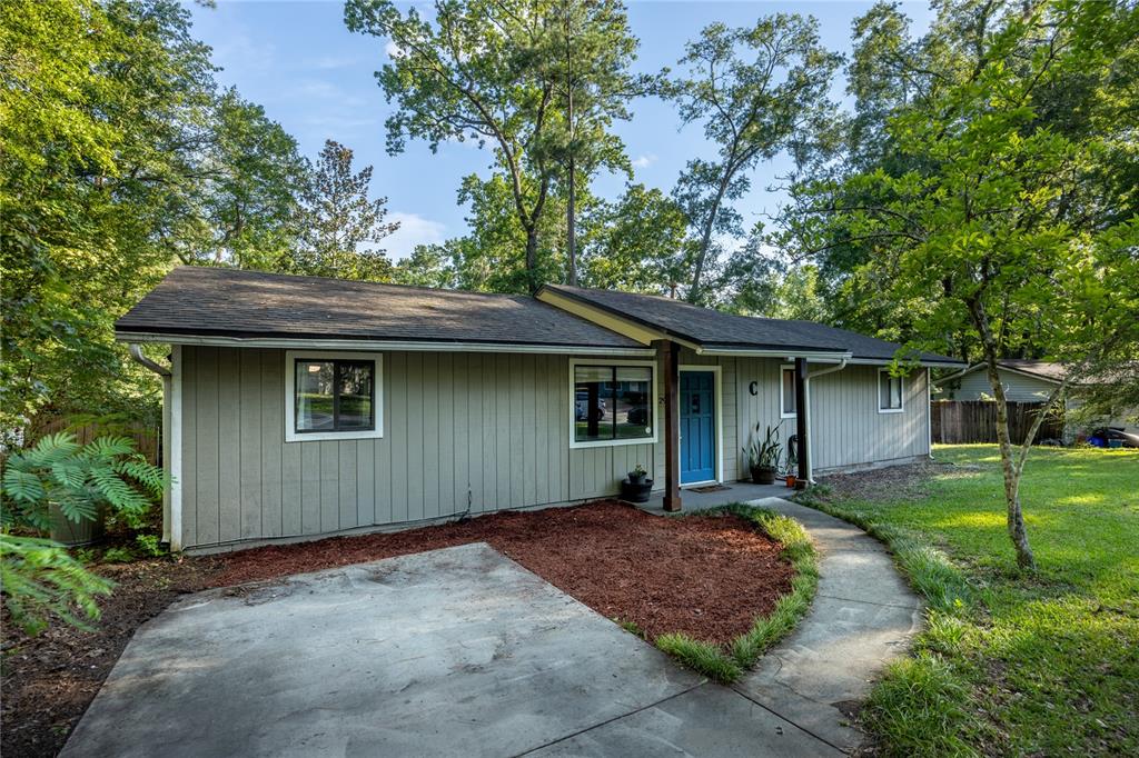 A single-story house with light green vertical siding, a blue front door, and a concrete walkway — 2937 NW 41ST PLACE, GAINESVILLE, FL