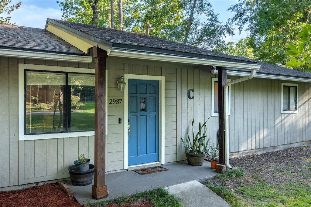 A single-story house exterior features a blue front door, a covered porch, and wood siding — 2937 NW 41ST PLACE, GAINESVILLE, FL